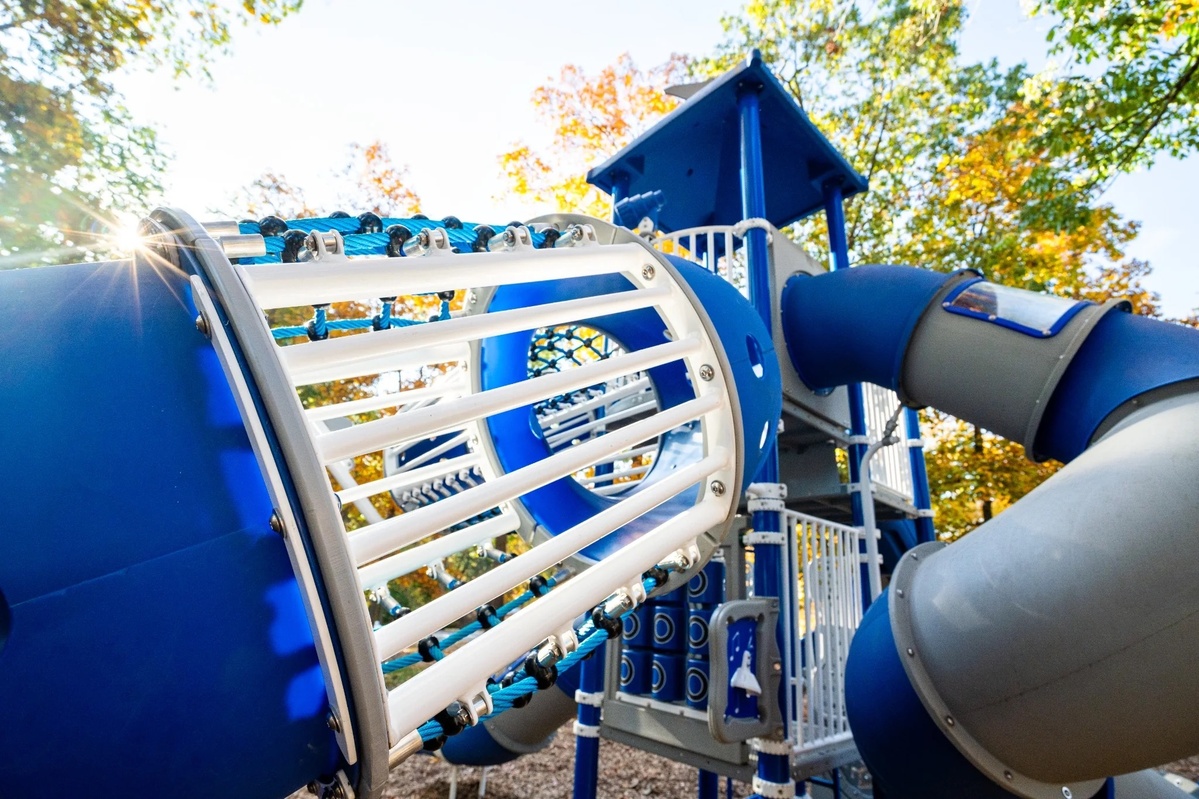 Close-up of a Playcraft blue tube, white climb-through bars and visible steel connections